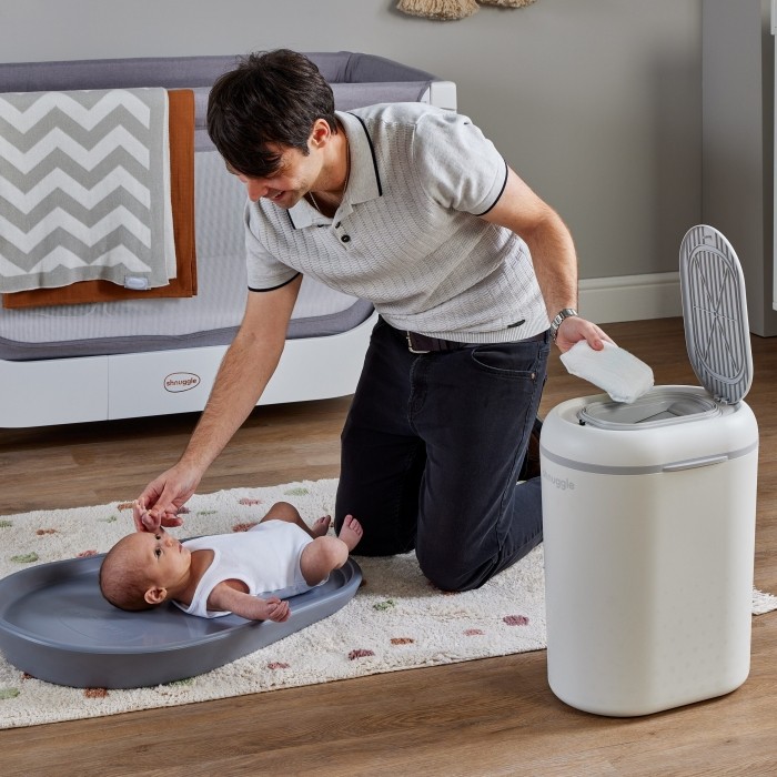 Dad-changing-baby-on-floor_dropping-bin-into-nappy-square-high-res-scaled